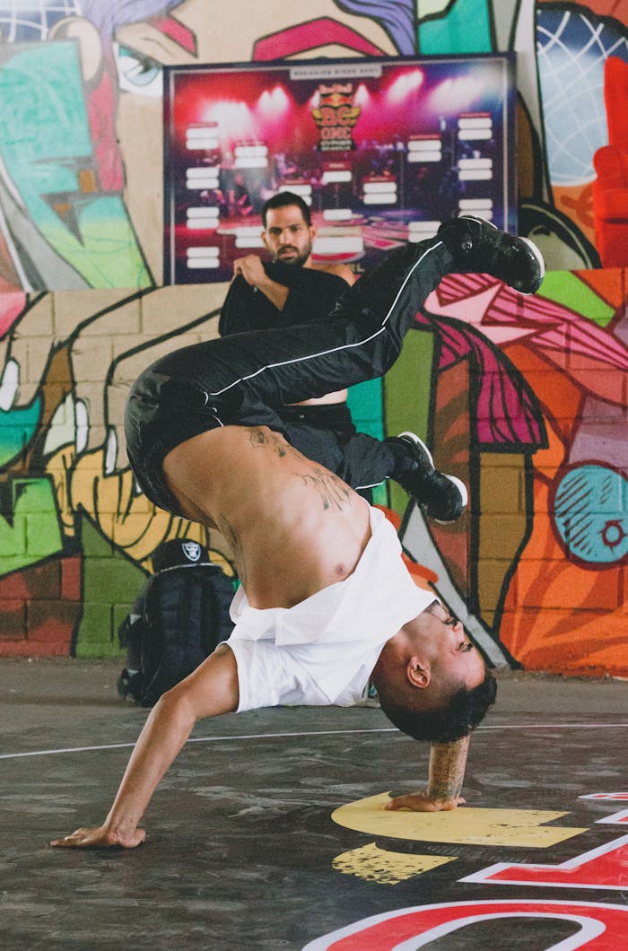 Energetic breakdancer in a vibrant urban setting executes a dynamic handstand move.