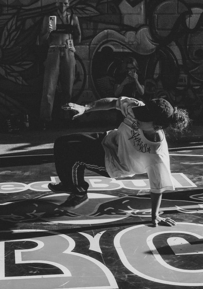 Energetic street dancer captured in motion against a vibrant mural backdrop.