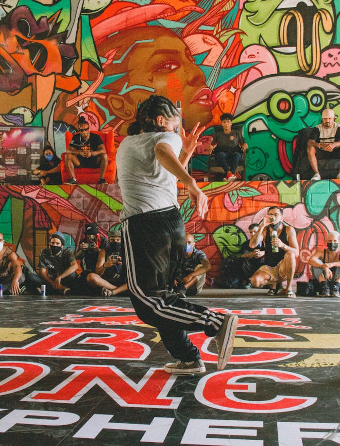Energetic breakdancer showcases moves in front of colorful graffiti, embodying urban culture and expressive dance.